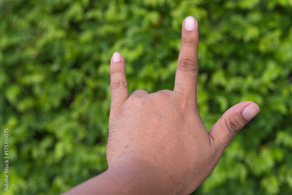 Male hand with I Love You sign on bokeh background in garden. Concept love nature. Male hand with I Love You sign on bokeh background in garden. Concept love nature.