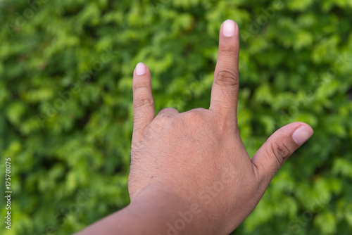 Male hand with I Love You sign  on bokeh background in garden. Concept love nature. © vipubadee