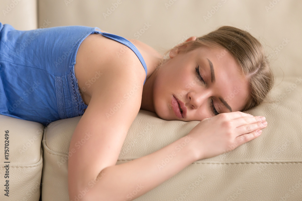 Beautiful young woman sleeping on couch, pretty tired girl lying asleep on  sofa, stressed lady taking nap at home passed out after sleepless night,  teenager dozing in daytime, head shot portrait Stock
