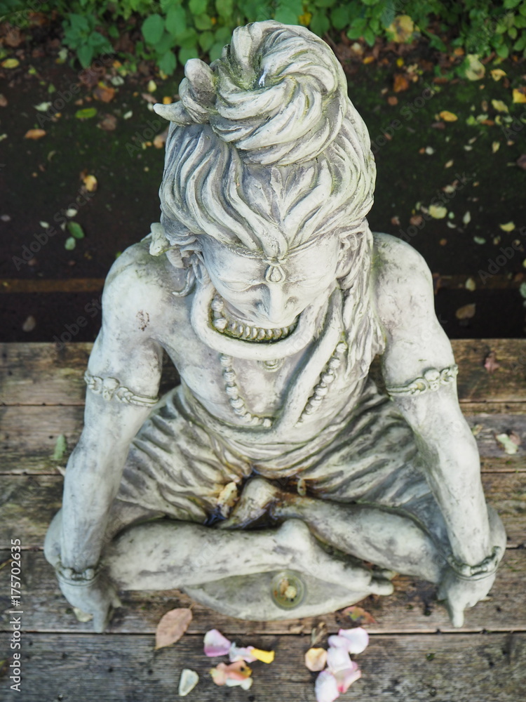 Shiva Statue aus Stein sitzend auf Holzplattform aus Vogelperspektive