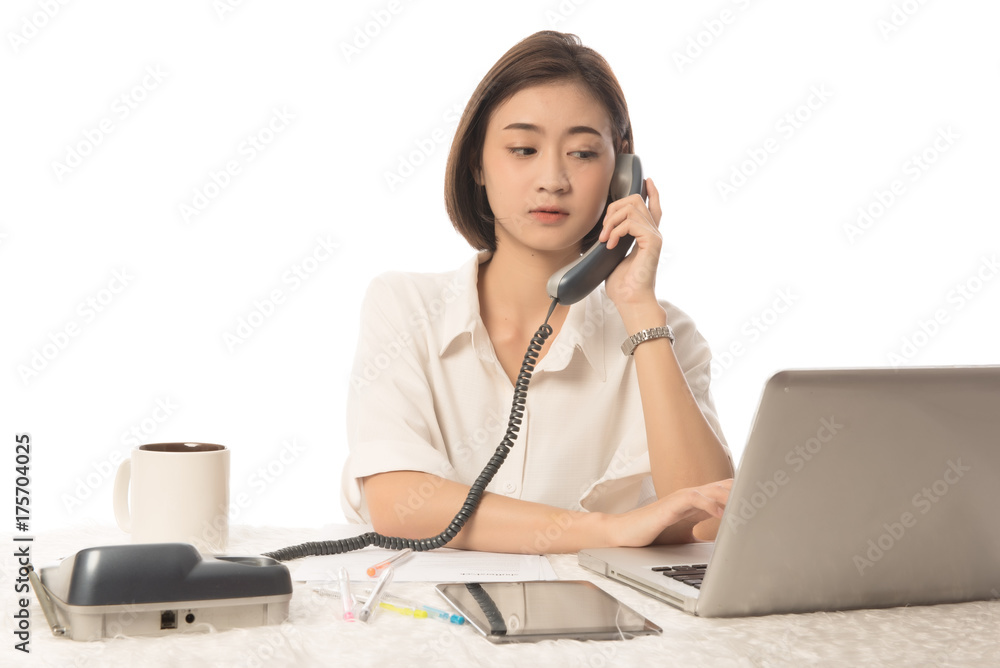 Portrait of young asian woman sitting at her desk working and answering a phone call. This image for working woman. Portrait of young asian woman sitting at her desk working and answering a phone call. This image for working woman.