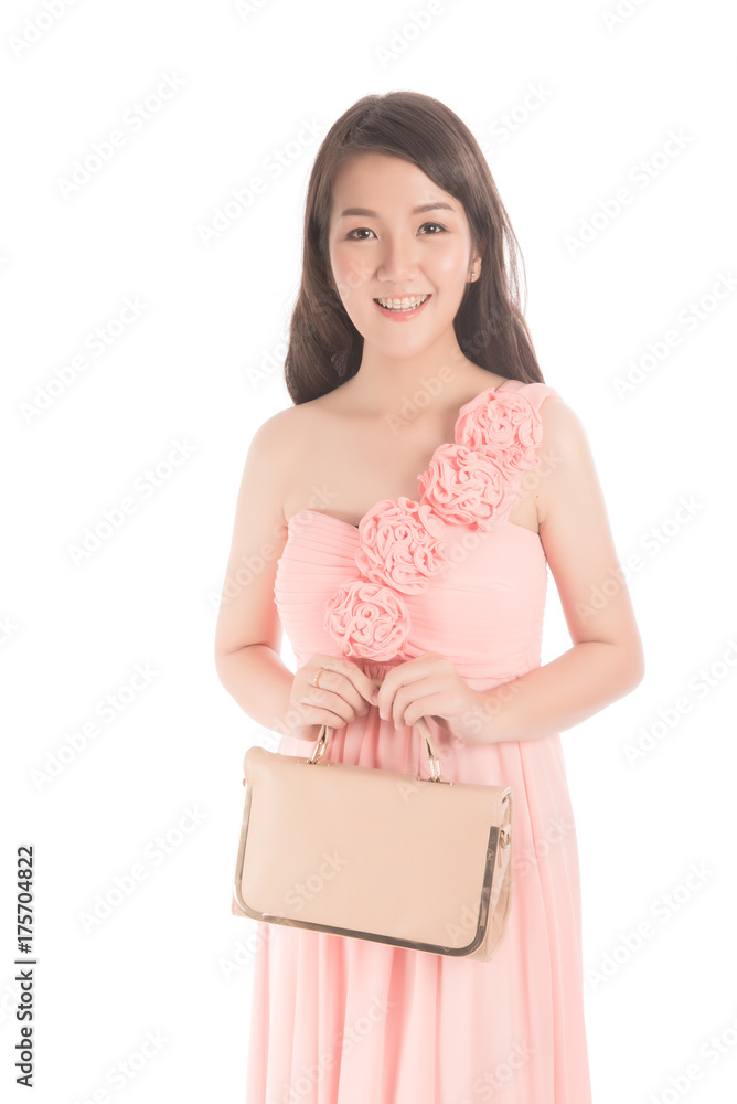 Beautiful happy asian woman wearing pink dress and holding a bag. Portrait of stylish Thai woman holding bag look at camera on white background. Beautiful happy asian woman wearing pink dress and holding a bag. Portrait of stylish Thai woman holding bag look at camera on white background.
