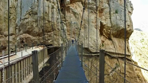 People crossing the suspension bridge in Royal Trail (El Caminito del Rey) in gorge Chorro, Malaga province, Spain