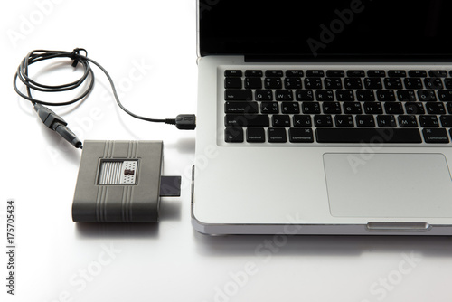 SD card and card reader conected to laptop close-up. photo