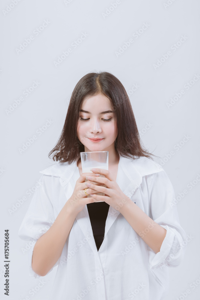 Asian woman drinking milk, happy and smiling beautiful young woman enjoying a glass milk. Thai woman with milk in studio. Asian woman drinking milk, happy and smiling beautiful young woman enjoying a glass milk. Thai woman with milk in studio.