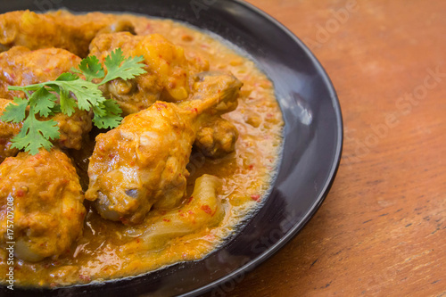Massaman chicken placed on a wooden table Old brown.,spicy muslim curry muslim food spicy. Eaten with rice or roti