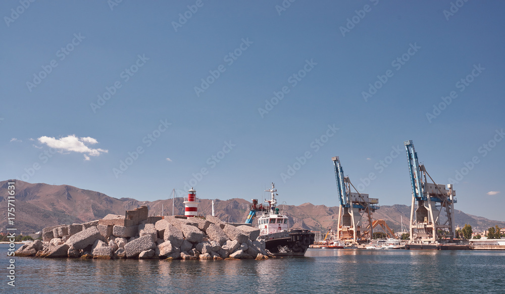 Harbor of Palermo, harbor crane, men fishing on the pier mountains in background