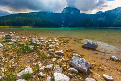 Stone on the background of azure lake and mountain Bobotov Kuk.