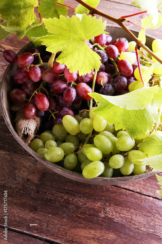 Grapes on wooden table and grape leaves . Healthy fresh fruit wine grapes.