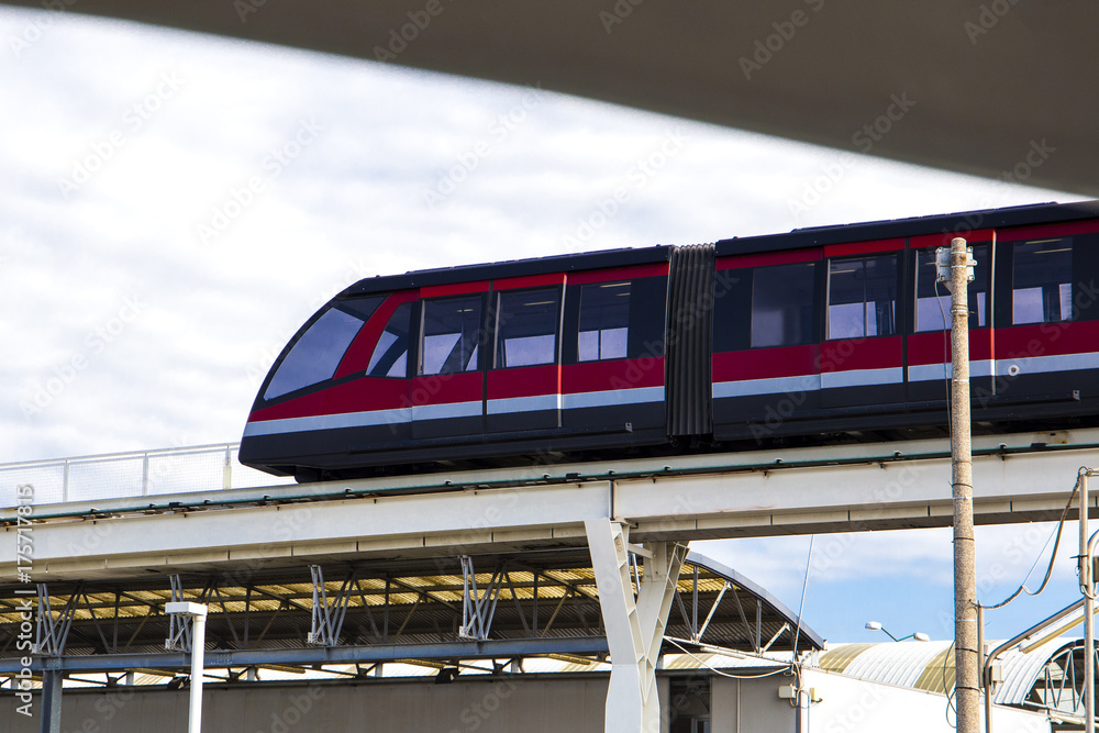 red modern underground train on the bridge above the ground
