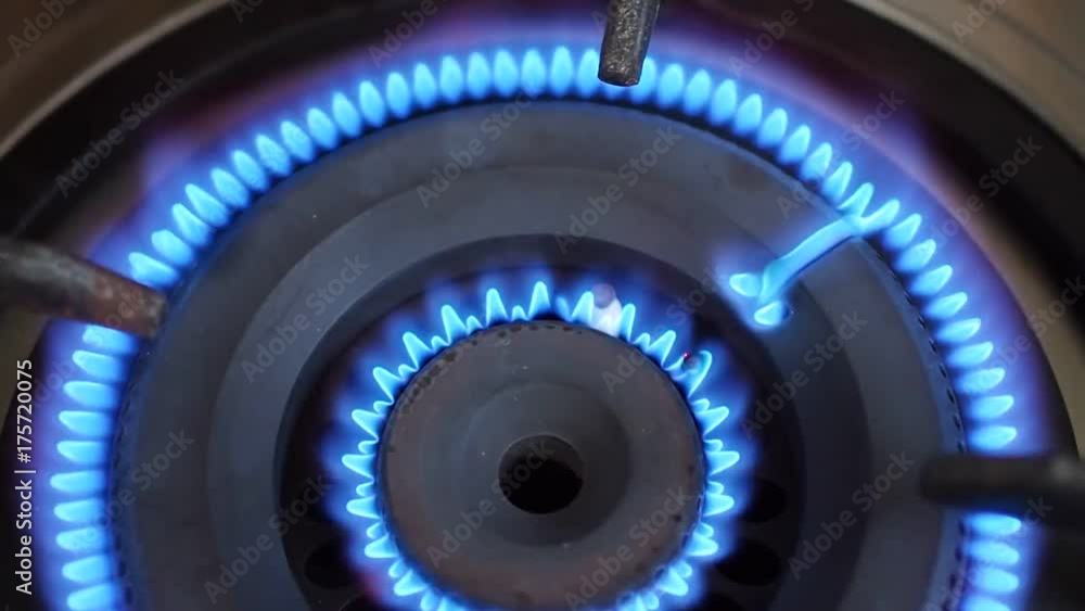 Top view close up of moving blue flame lid, sparking, from traditional cooking stainless steel gas stove, unstable fire heating area Top view close up of moving blue flame lid, sparking, from traditional cooking stainless steel gas stove, unstable fire heating area