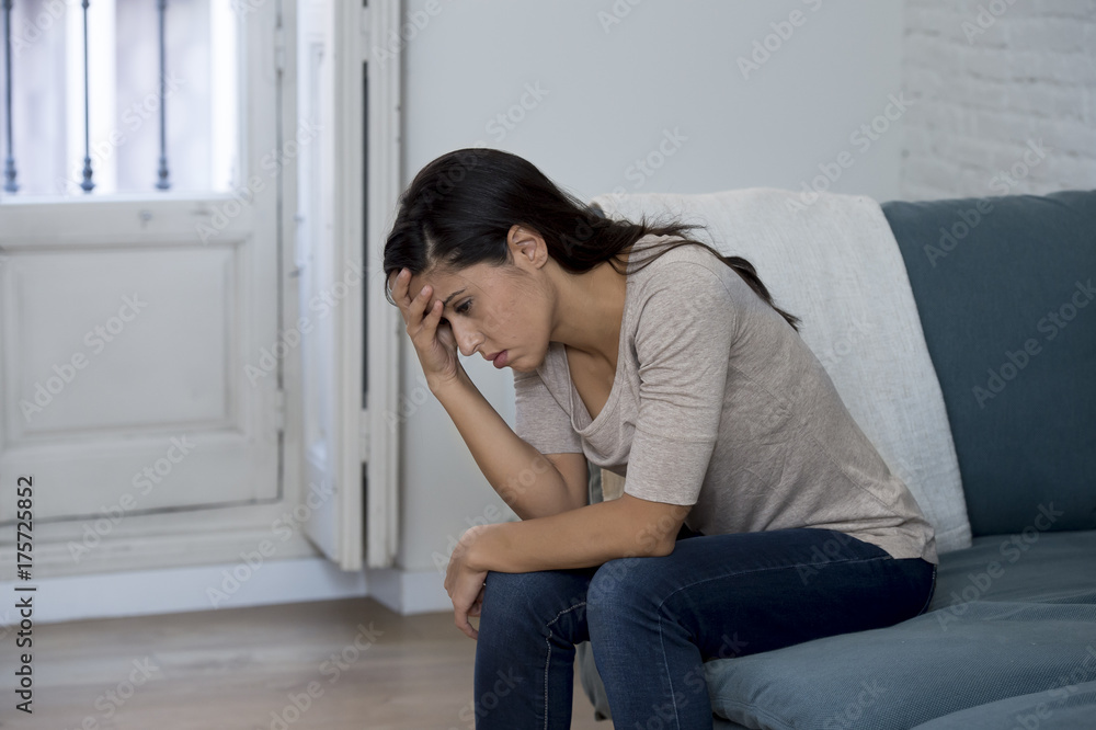 latin woman lying at home sitting on couch crying worried suffering depression feeling sad latin woman lying at home sitting on couch crying worried suffering depression feeling sad