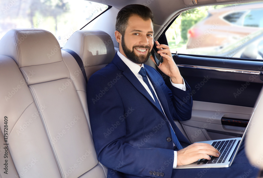 Businessman in elegant suit on backseat of car Businessman in elegant suit on backseat of car