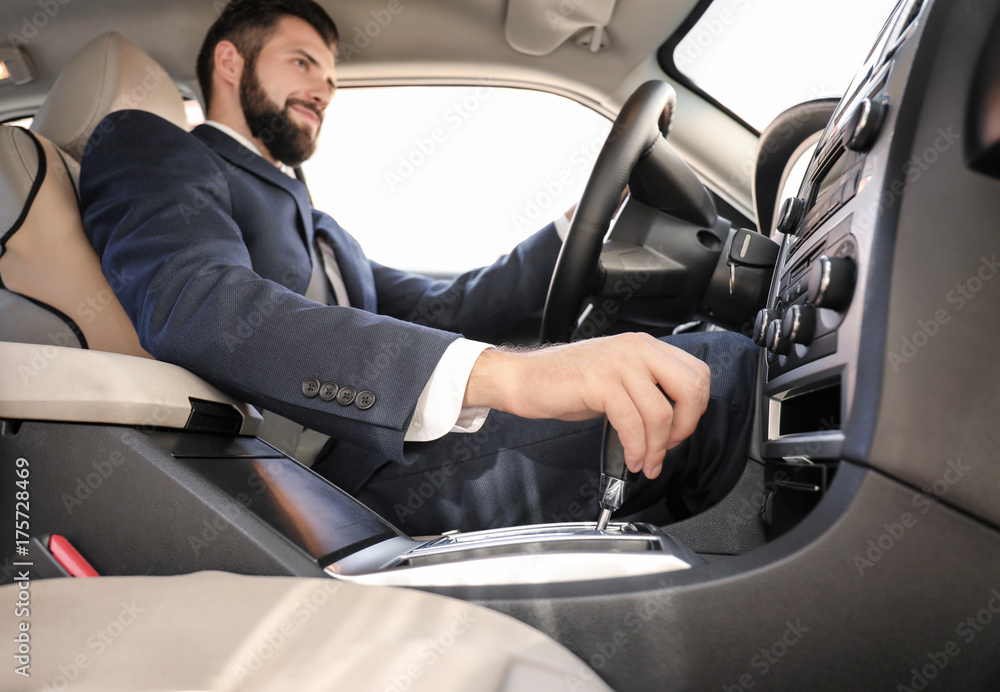 Handsome man in formal suit on driver's seat of car Handsome man in formal suit on driver's seat of car