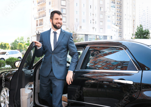 Wallpaper Mural Handsome man in suit getting out of car Torontodigital.ca