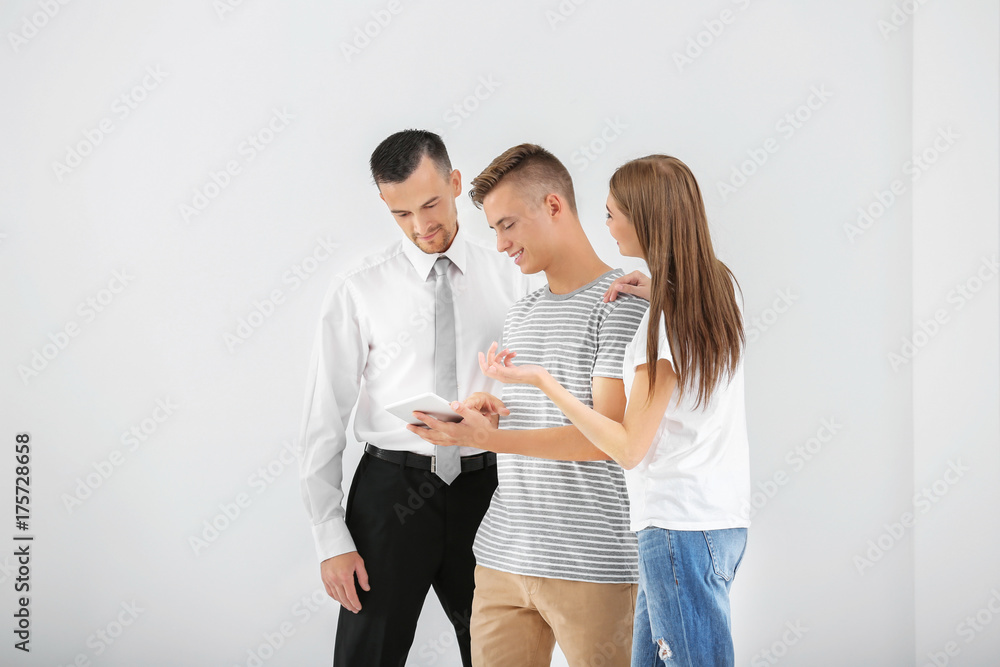 Happy family with tablet and estate agent in light new apartment Happy family with tablet and estate agent in light new apartment