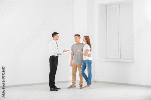 Happy family with estate agent in light new apartment