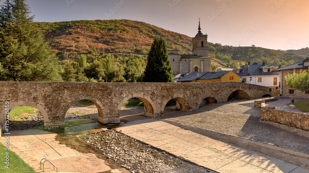 Dry river bed under Roman bridge during drought in Molinaseca, Spain.
