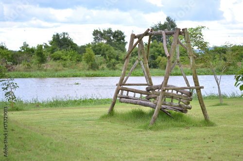 Old swing wood chair on grass near river 