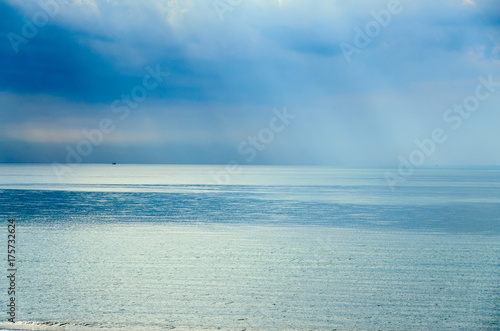 The Black Sea shore with blue fresh clear water, mystical clouds sky