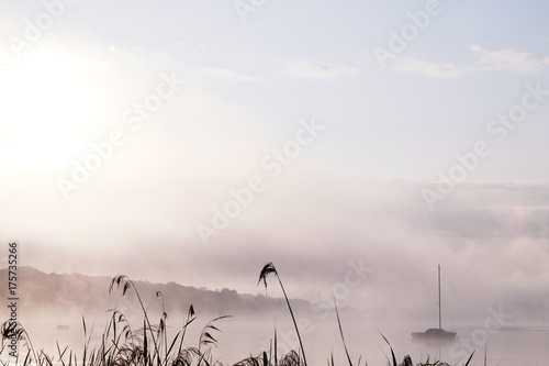 Morning mist over lake with sailboat - 3