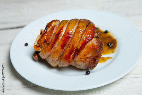 Roasted pork isolated on white plate. Smoked and roasted knuckle of pork on bright background. photo
