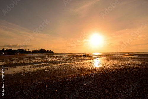 The sun shines on the horizon and reflects down on the water surface