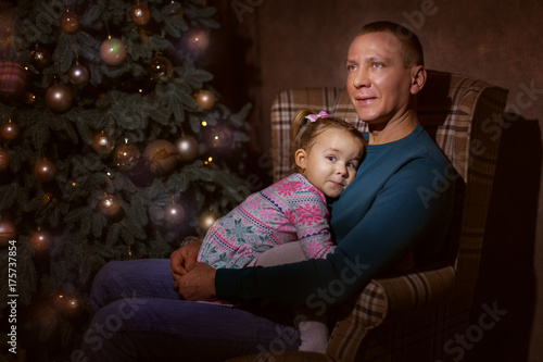 Father and daughter in the living room near the Christmas tree © silkstocking