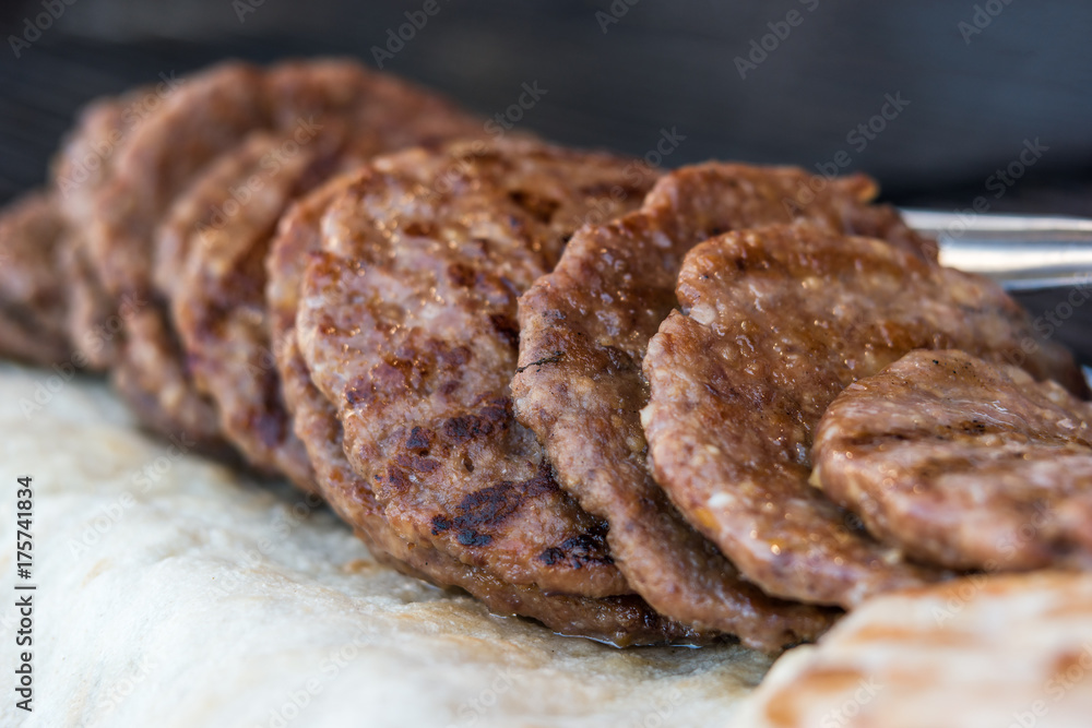 grilled pljeskavica stacked on a fair stall, selective focus grilled pljeskavica stacked on a fair stall, selective focus
