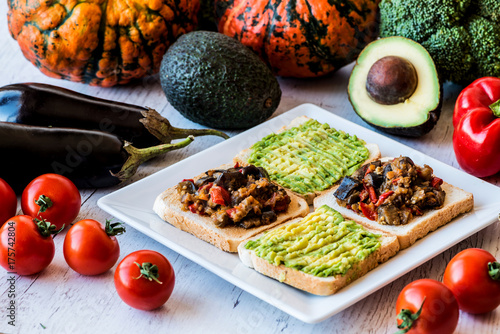 Vegetarian food. Toasts with stewed vegetables and avocado on the white plate