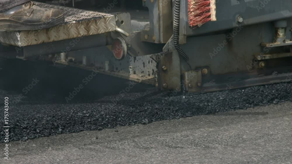 Asphalt paver machine on new road construction site extreme close up shot