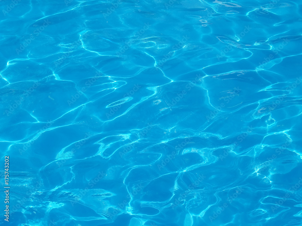 rippled that reflect sunlight on blue water surface in resort swimming pool
