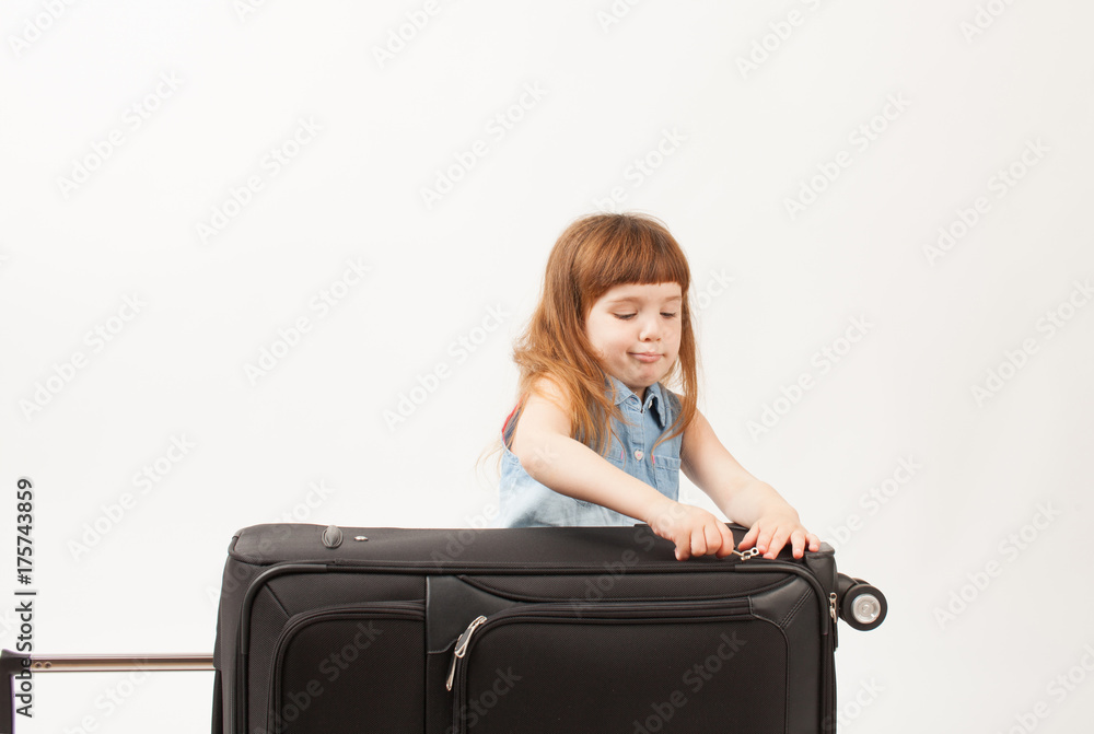 The girl closes suitcase on white background The girl closes suitcase on white background