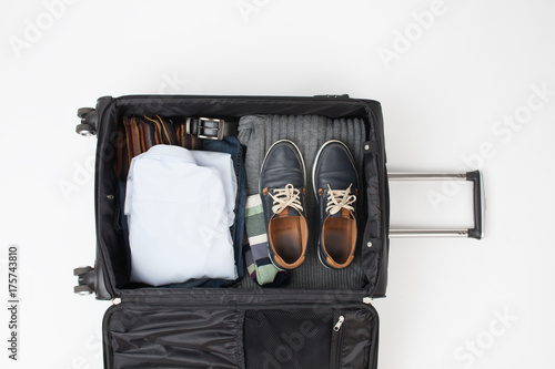 Outdoor travel black suitcase with things on a white