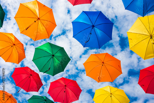 Many colorful umbrellas hanging in the sky