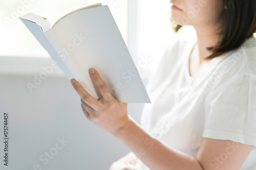Blurred of women reading book in the warm light morning.