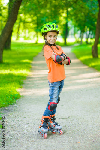 Portrait of a girl with arms crossed in a protective helmet and protective pads for roller skating