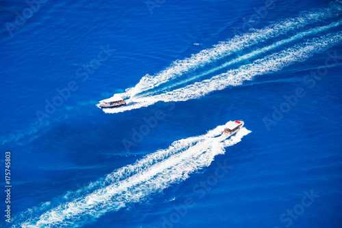 Two motor boats going on high speed in blue sea