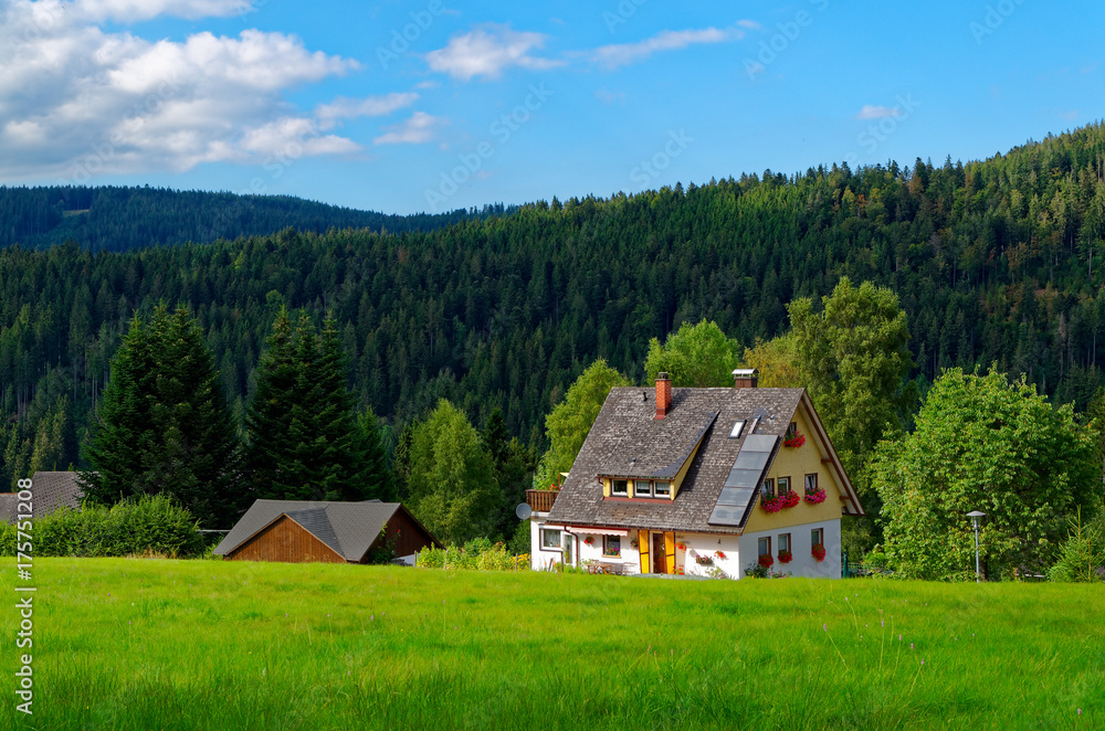 Blick auf ein wunderschönes Haus unter dem blauen Himmel und Schwarzwald im Hintergrund 