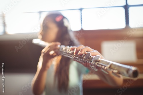Photo Girl practicing flute in classroom