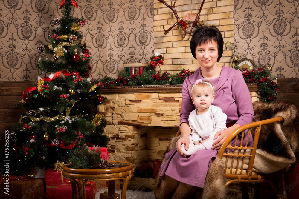 happy mother and child near christmas tree and fireplace at home