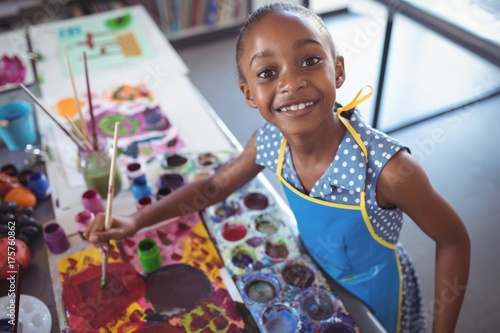 High angle portrait of elementary girl painting at desk