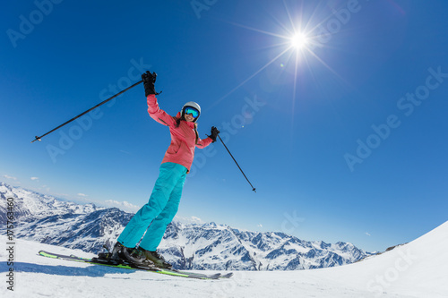 Happy young woman skier enjoying sunny weather in Alps
