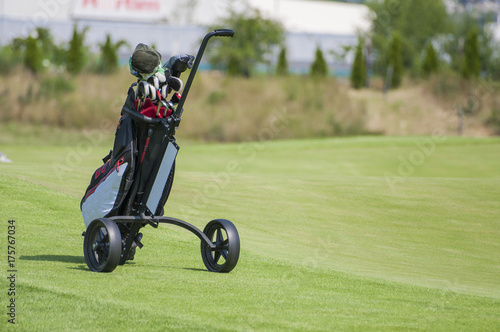 Golf trolley with clubs in golf curse
