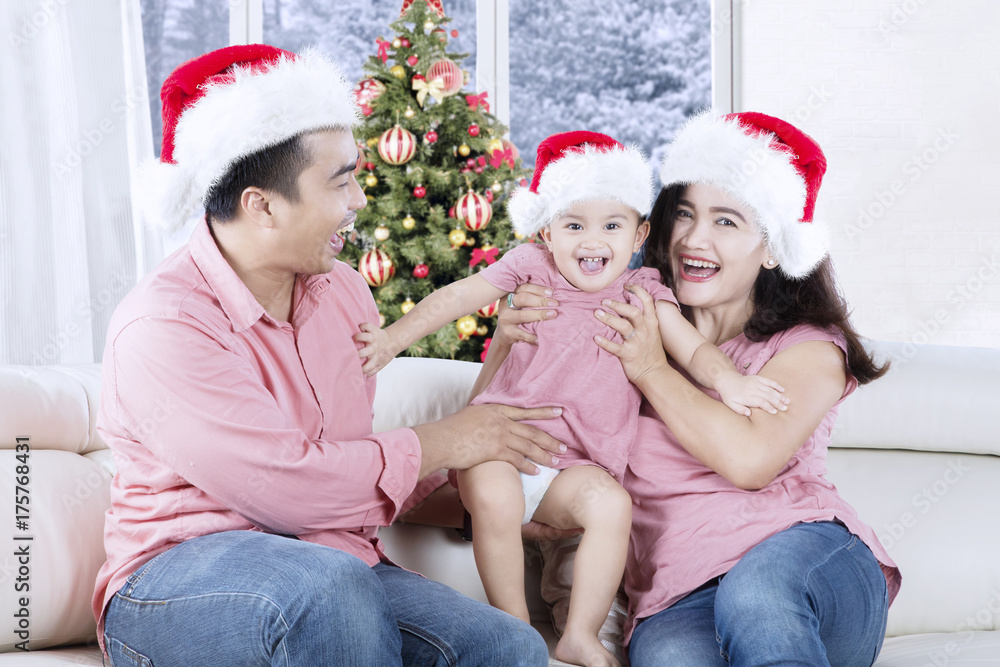 Parents play with their daughter at Christmas time Parents play with their daughter at Christmas time