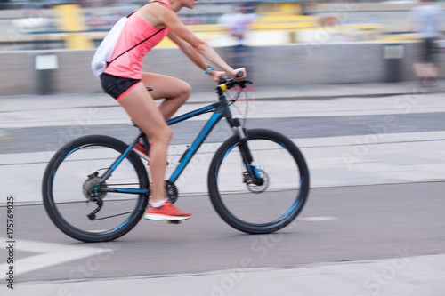the girl rides a bicycle through the summer city