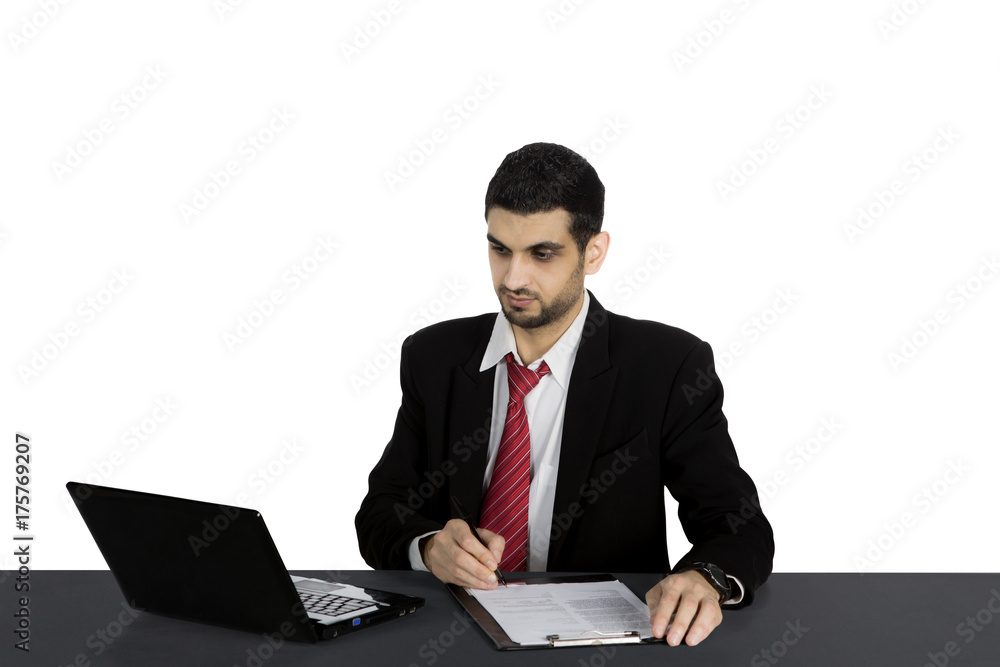 Italian businessman working with clipboard and laptop Italian businessman working with clipboard and laptop