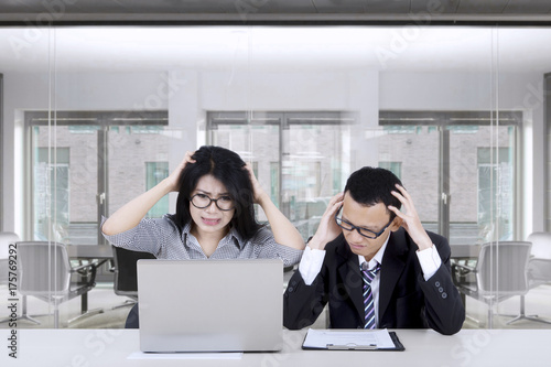 Frustrated entrepreneurs looking at laptop