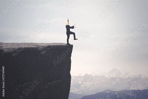 Disoriented businessman walks on the cliff