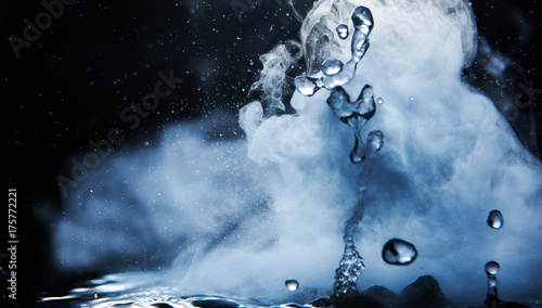 Canvastavla Boiling water splash with steam on black background closeup